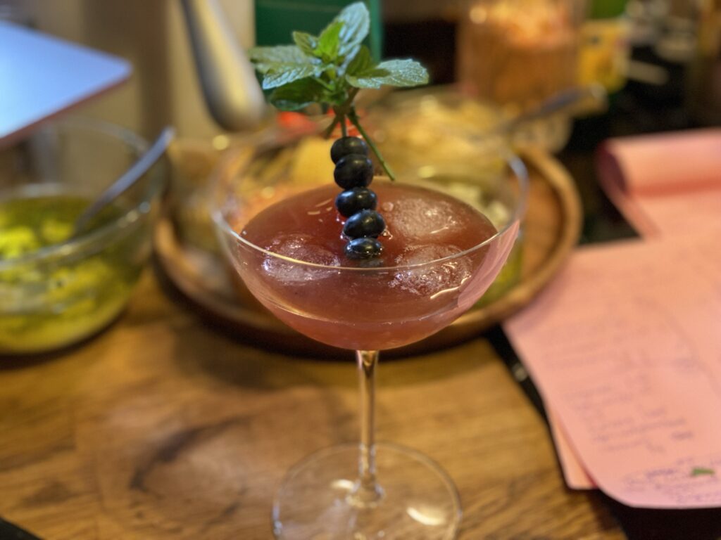 Light purple cocktail with blueberries on a stick for garnish