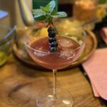 Light purple cocktail with blueberries on a stick for garnish