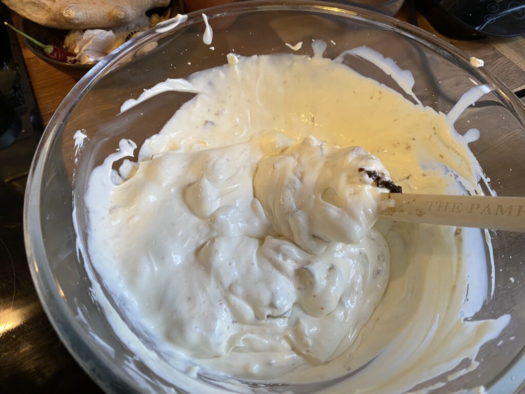Bowl with the creams and the prunes and marzipan being stirred in