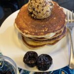 Stack of pancakes with a scoop of prune button top and melting