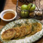Green and white oval plate with slices of fried green tomatoes