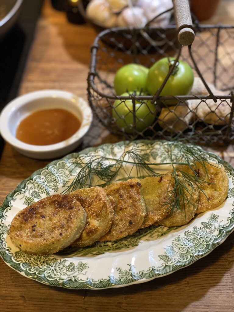 Green and white oval plate with slices of fried green tomatoes